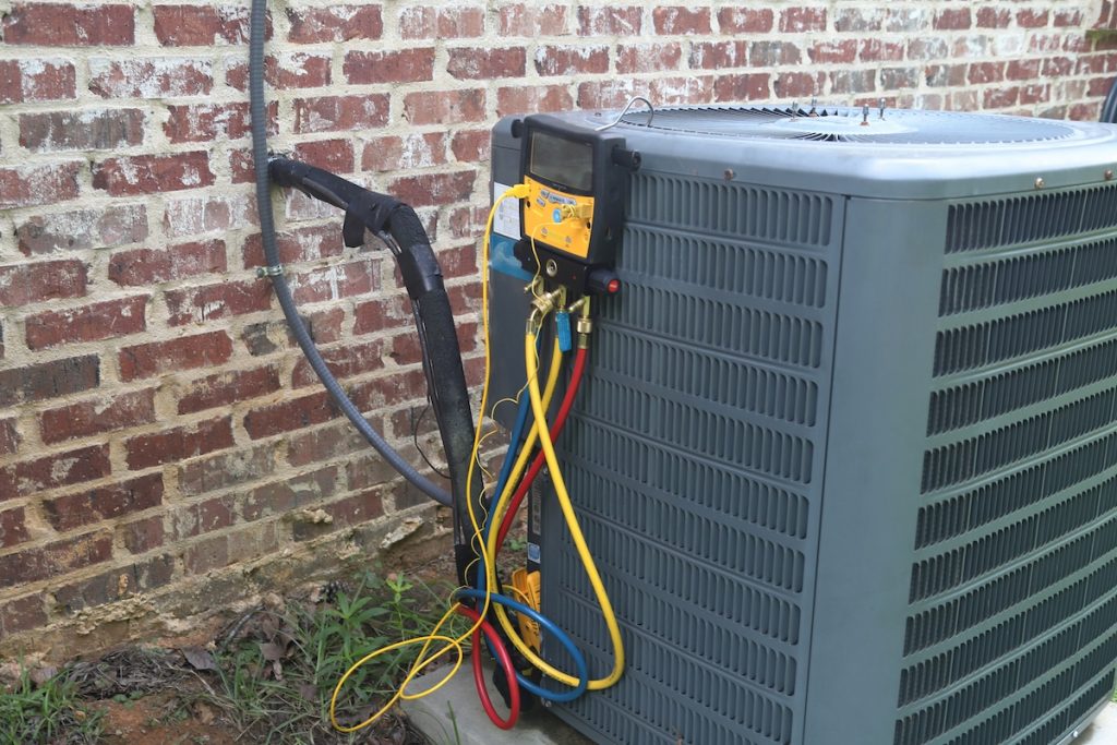 An air conditioning unit with a device on it to test if the A/C unit is working. 