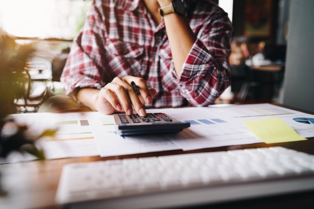 A person using a calculator to figure out the best way to finance home improvements.