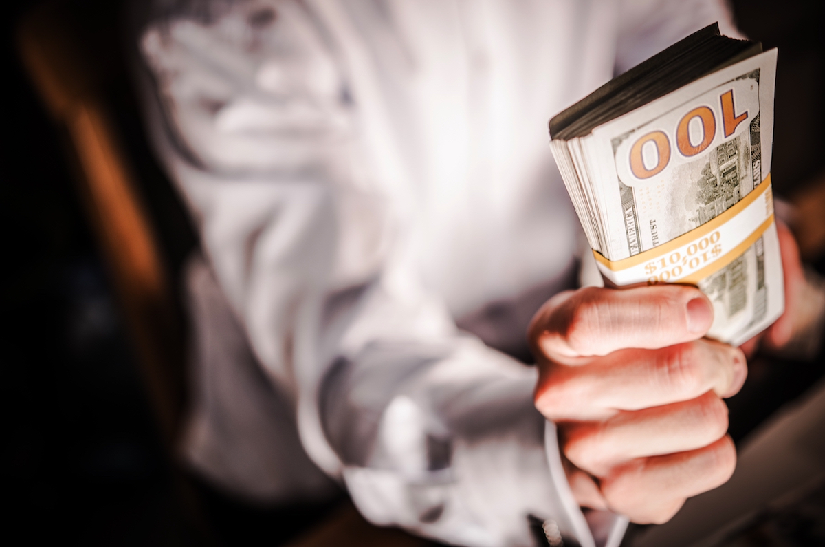 A man handing over $10,000 in cash for a home improvement project.