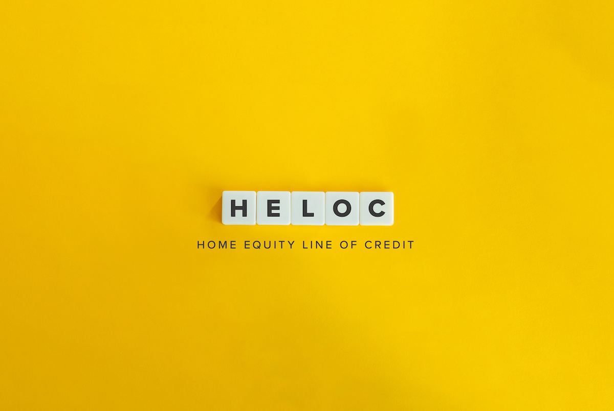 Scrabble letters that spell out "HELOC" on a yellow background.