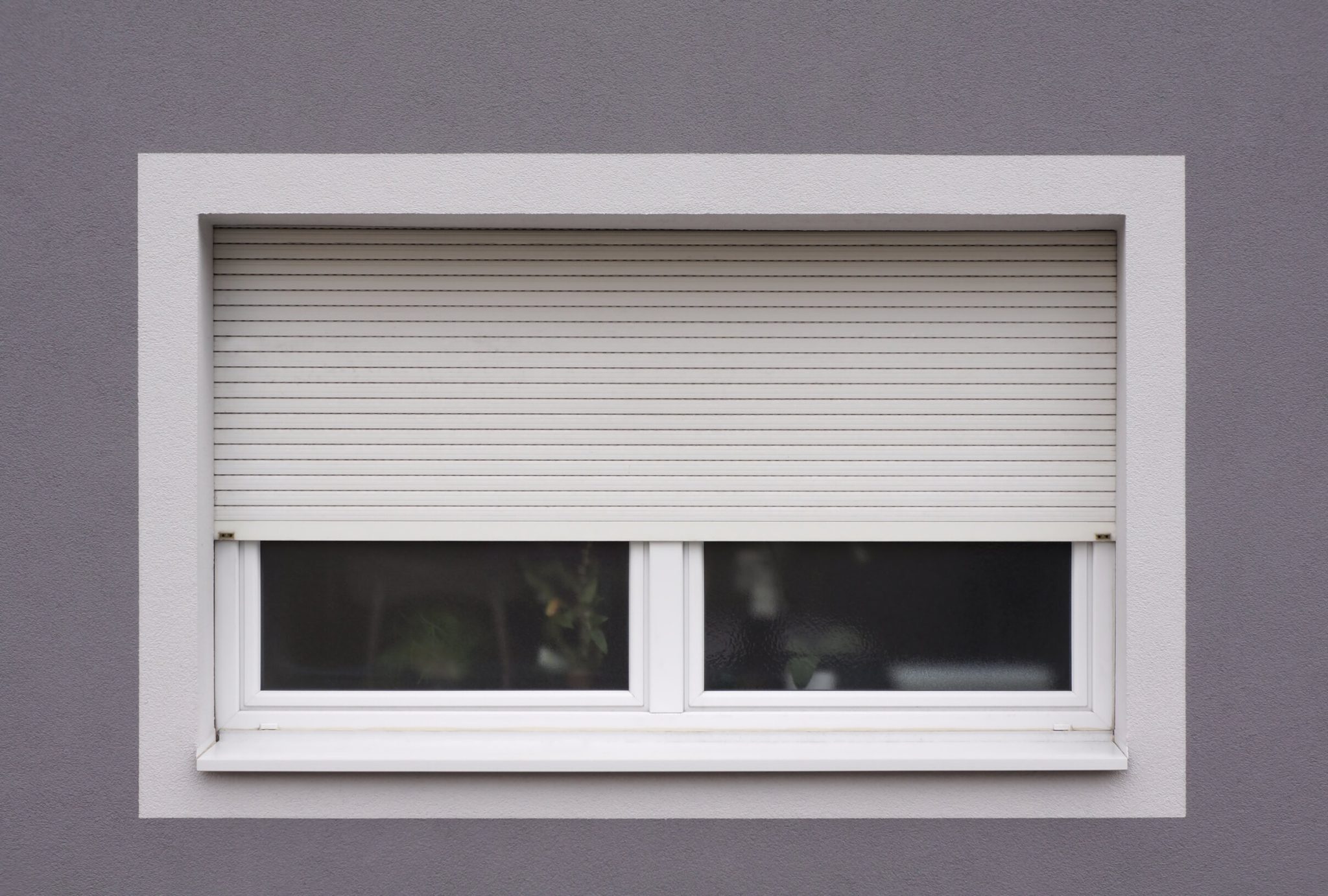 Closed, impact-resistant window with a protective shutter installed.