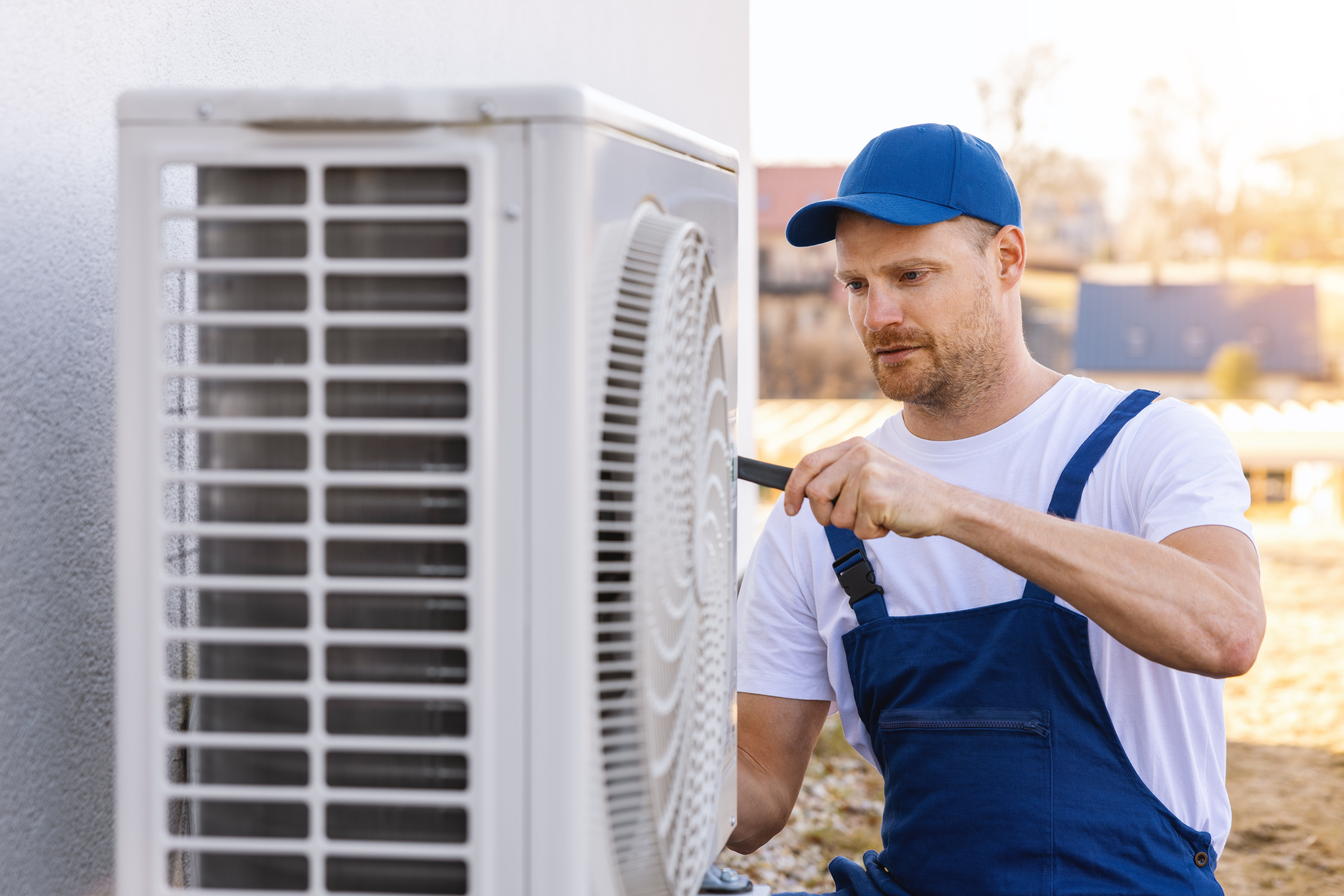 AC Repair vs Replacement in Florida: How to Decide (and Financing Options) 2 HVAC technician inspecting an outdoor air conditioning unit at a home.